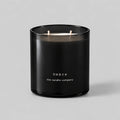 Ombre 400g candle in black smoked glass with two cotton wicks on a neutral grey background
